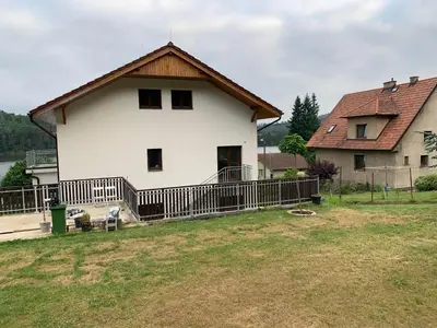 a large white house with a fence in a yard at Apartmány Županovice in Dobříš
