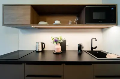 a kitchen counter with a sink and a microwave at Karl BY ZEITRAUM in Prague
