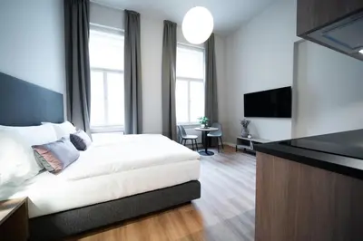 a bedroom with a white bed and a flat screen tv at Karl BY ZEITRAUM in Prague