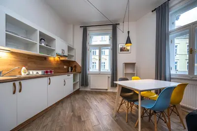 a kitchen and dining room with a table and chairs at Folimanka Apartments in Prague