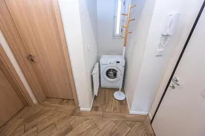 a small bathroom with a washing machine in it at Folimanka Apartments in Prague