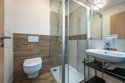 a bathroom with a toilet and a sink and a shower at Folimanka Apartments in Prague