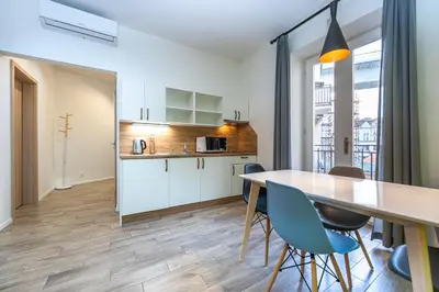 a kitchen and dining room with a table and chairs at Folimanka Apartments in Prague