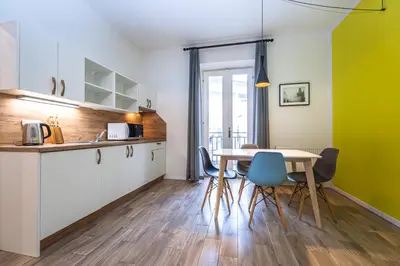 a kitchen and dining room with a table and chairs at Folimanka Apartments in Prague