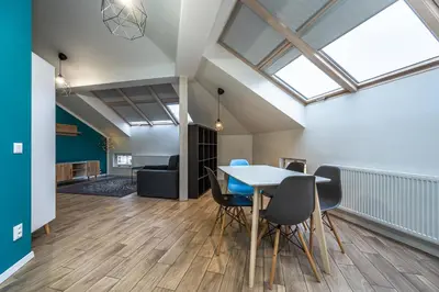 an open living room with a table and chairs at Folimanka Apartments in Prague