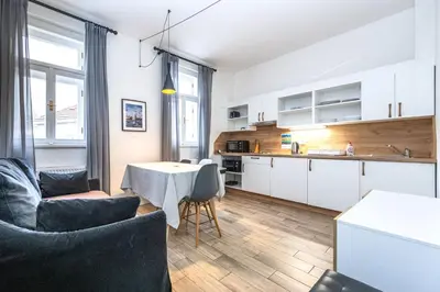 a kitchen and living room with a table and chairs at Folimanka Apartments in Prague
