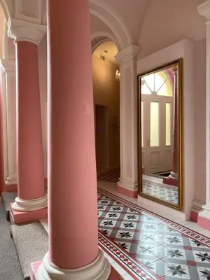 a hallway with columns and a mirror in a room at Angelo Roma in Prague