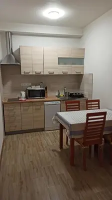 a kitchen with a table and chairs and a kitchen with white cabinets at Apartmán Poděbrady in Poděbrady