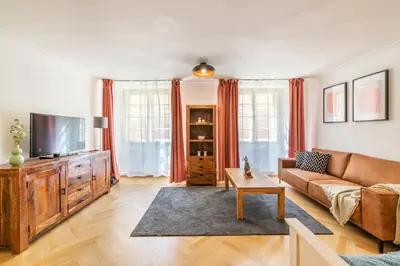 a living room with a couch and a tv at Celetná - Old Town Residence in Prague