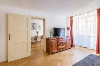 a living room with a television on a dresser and a door at Celetná - Old Town Residence in Prague