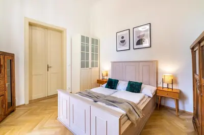 a bedroom with a large white bed and two lamps at Celetná - Old Town Residence in Prague