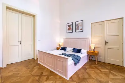 a bedroom with a large bed and two doors at Celetná - Old Town Residence in Prague