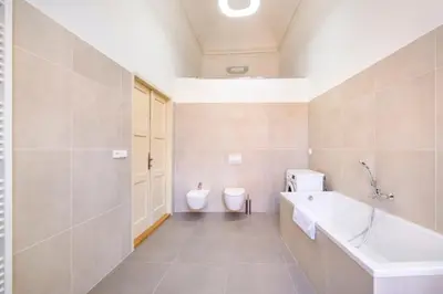 a bathroom with a tub and a toilet and a sink at Celetná - Old Town Residence in Prague