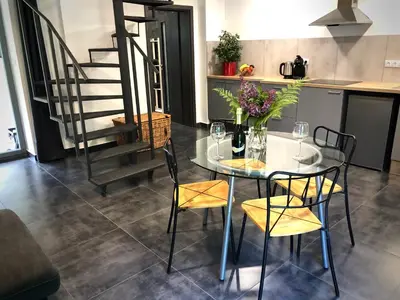 a dining room with a glass table and chairs at Mezonetový apartmán s terasou na samotě v lese in Vlkava