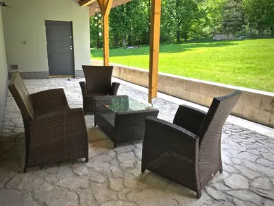 a group of chairs and a table on a patio at Mezonetový apartmán s terasou na samotě v lese in Vlkava