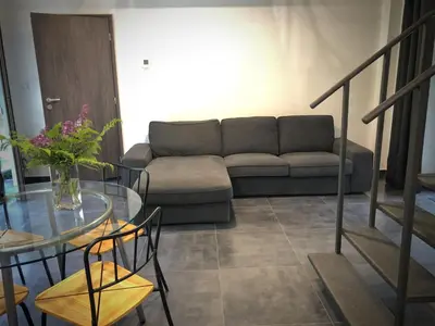 a living room with a couch and a glass table at Mezonetový apartmán s terasou na samotě v lese in Vlkava
