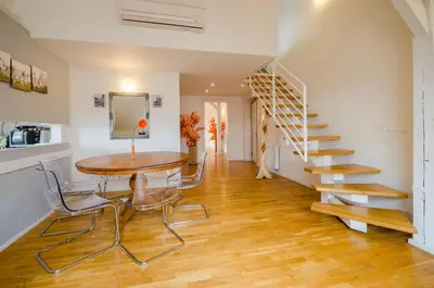 a dining room with a table and a spiral staircase at Historic Centre Apartments I in Prague