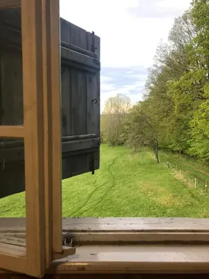 an open window with a view of a field at Chata s duší in Beroun