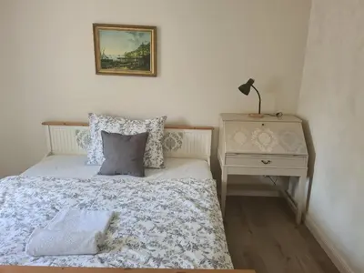 a small bedroom with a bed and a night stand at Airport Rooms in Prague