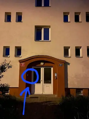 a building with a blue ribbon in front of a door at Airport Rooms in Prague