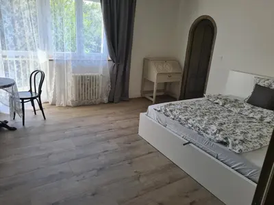 a bedroom with a bed and a table and a window at Airport Rooms in Prague