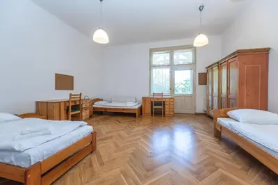 a large room with two beds and wooden floors at Jiriho z Podebrad Apartments in Prague