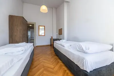 a row of beds in a room with wood floors at Jiriho z Podebrad Apartments in Prague