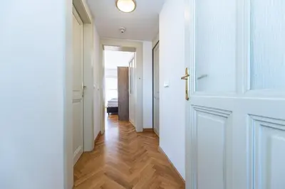 a hallway with a white door and a wooden floor at Jiriho z Podebrad Apartments in Prague