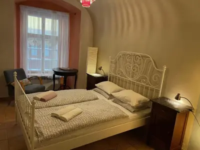 a bedroom with a white bed with a chair and a window at 1 Bed Flat - Sleeps 3 - Pets - Wifi in Prague