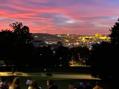 a group of people standing in a park at sunset at Designed apartment next to Vaclav square with terrace and private garage in Prague