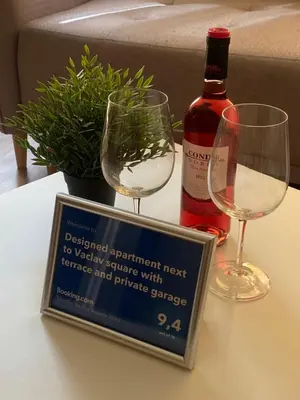 a bottle of wine and two glasses on a table at Designed apartment next to Vaclav square with terrace and private garage in Prague