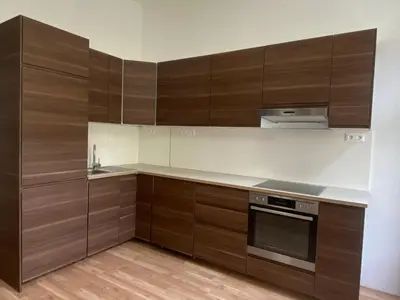 a kitchen with wooden cabinets and a stove top oven at Designed apartment next to Vaclav square with terrace and private garage in Prague