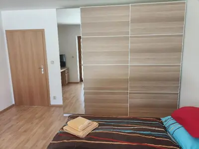 a bedroom with a large glass closet with a bed at Ubytování U Vrbičky - blízko Prahy in Unhošť