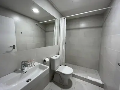 a white bathroom with a toilet and a sink at Figaro Suites in Prague