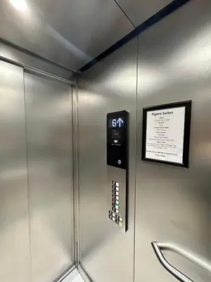 a metal elevator with a sign on a wall at Figaro Suites in Prague