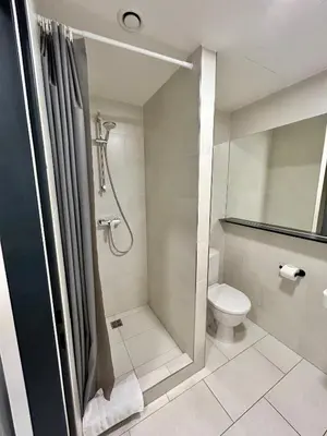 a bathroom with a shower and a toilet at Figaro Suites in Prague