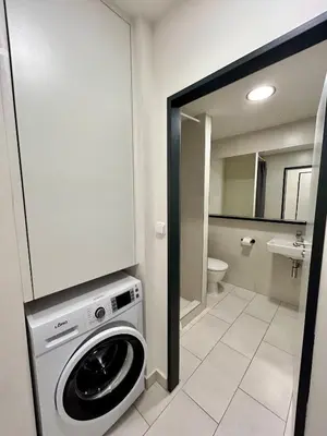 a bathroom with a washing machine in a room at Figaro Suites in Prague
