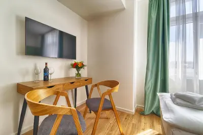 a room with a desk with two chairs and a tv at Luma Terra Prague Hostel in Prague