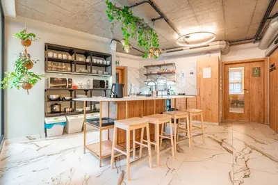 a kitchen with a table and stools at Luma Terra Prague Hostel in Prague
