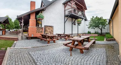 a group of picnic tables in front of a building at Penzion U Kapličky in Malá Hraštice
