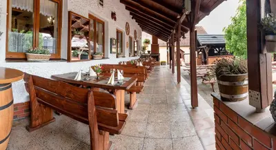 a row of wooden tables and benches on a patio at Penzion U Kapličky in Malá Hraštice