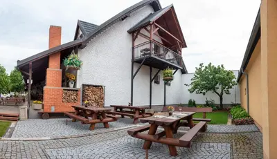 a group of picnic tables outside of a building at Penzion U Kapličky in Malá Hraštice