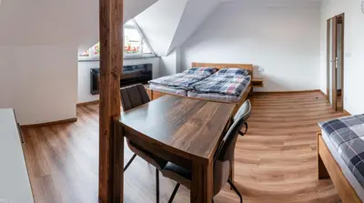 a room with a table and a bed in it at Penzion U Kapličky in Malá Hraštice