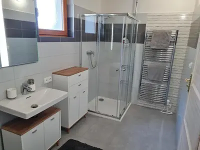 a white bathroom with a shower and a sink at Chata Eliška Hrdlička, Čím u Prahy in Čím