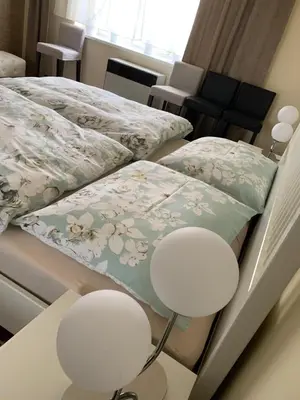 two beds in a room with two chairs and pillows at APARTMEN PRAHA in Prague