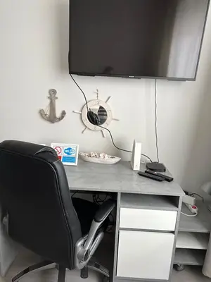 a desk with a chair and a television on a wall at APARTMEN PRAHA in Prague