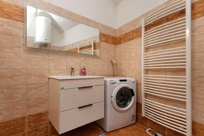 a bathroom with a washing machine and a sink at Riverside Apartment in Prague