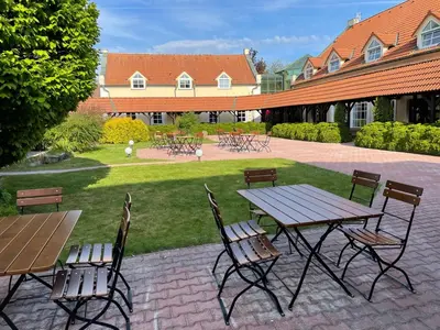 a picnic table and chairs in a courtyard at Bechnerův statek in Lány