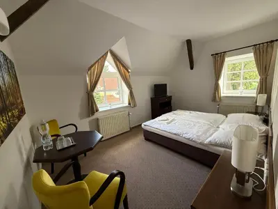 a bedroom with a bed and a table and chairs at Bechnerův statek in Lány