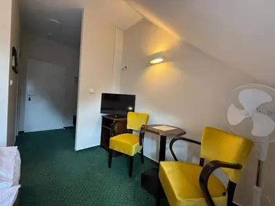 a room with two chairs and a desk and a tv at Bechnerův statek in Lány
